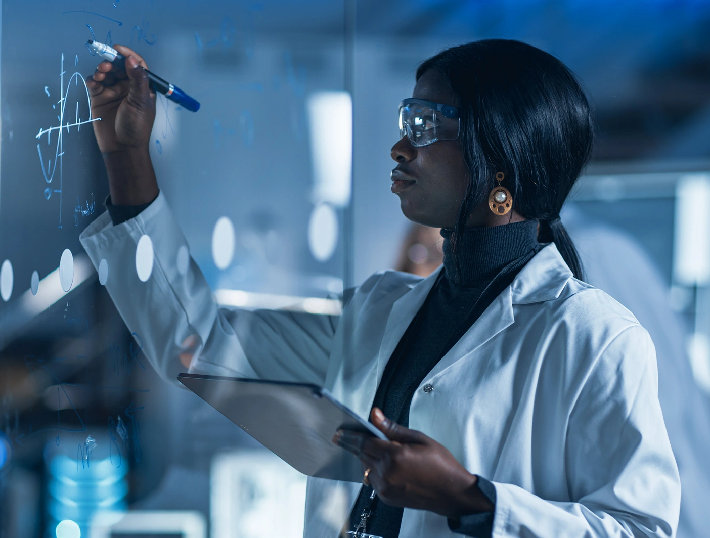 Scientist in a lab coat writing equations on glass, advancing cancer research with focused determination.